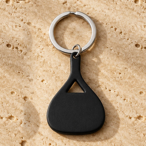 Padel Keychain in Schwarz auf Travertin